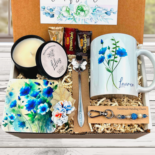 blue flower gift basket with personalized mug, candle, engraved spoon, matching coaster and scented candle.