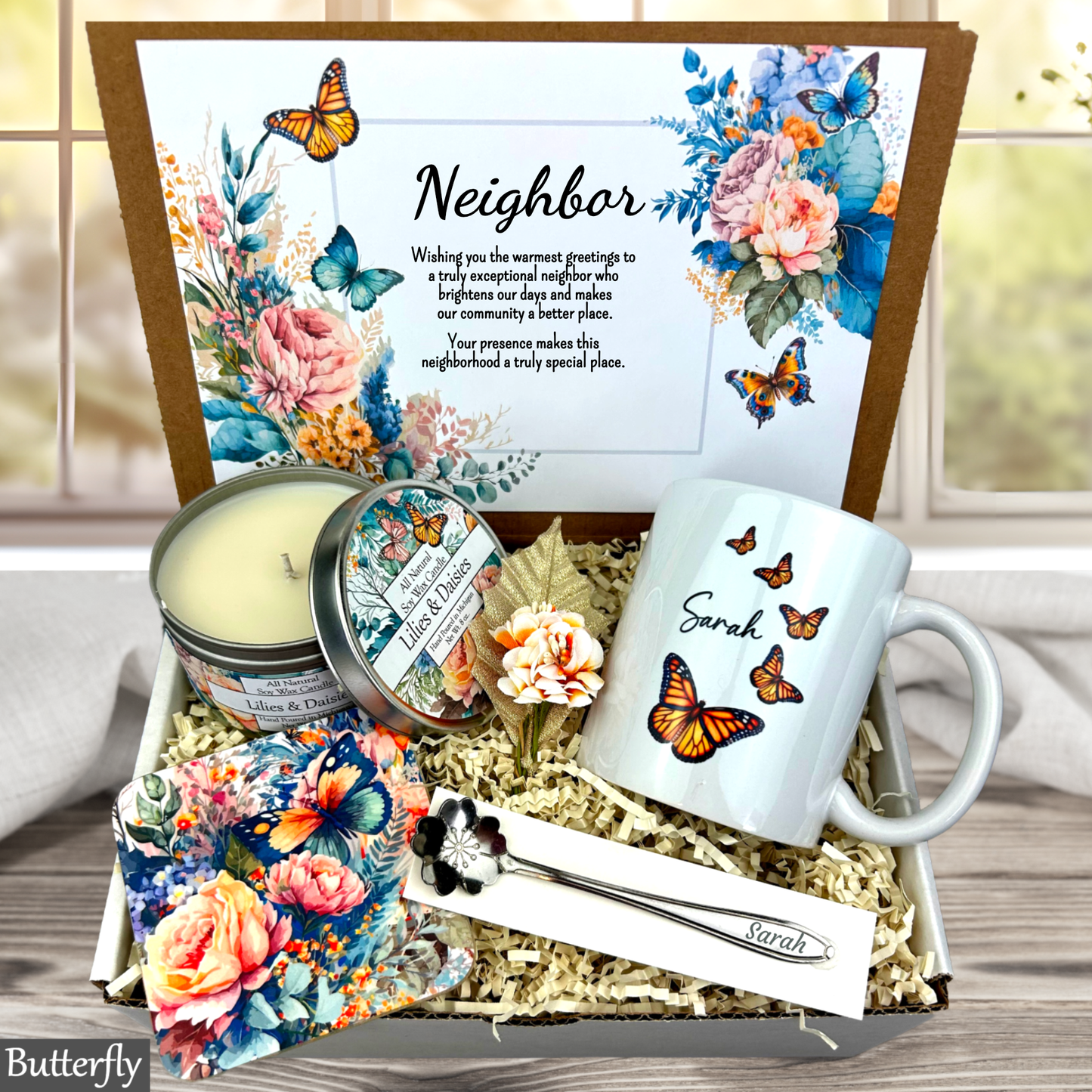 Gift box with 'Congratulations' card, mug, candle, and other items with butterfly design.
