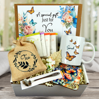 butterfly themed Personalized mug and engraved spoon set accompanied by a large 8-ounce scented candle, an assortment of five artisan teas, and a matching coaster set for women