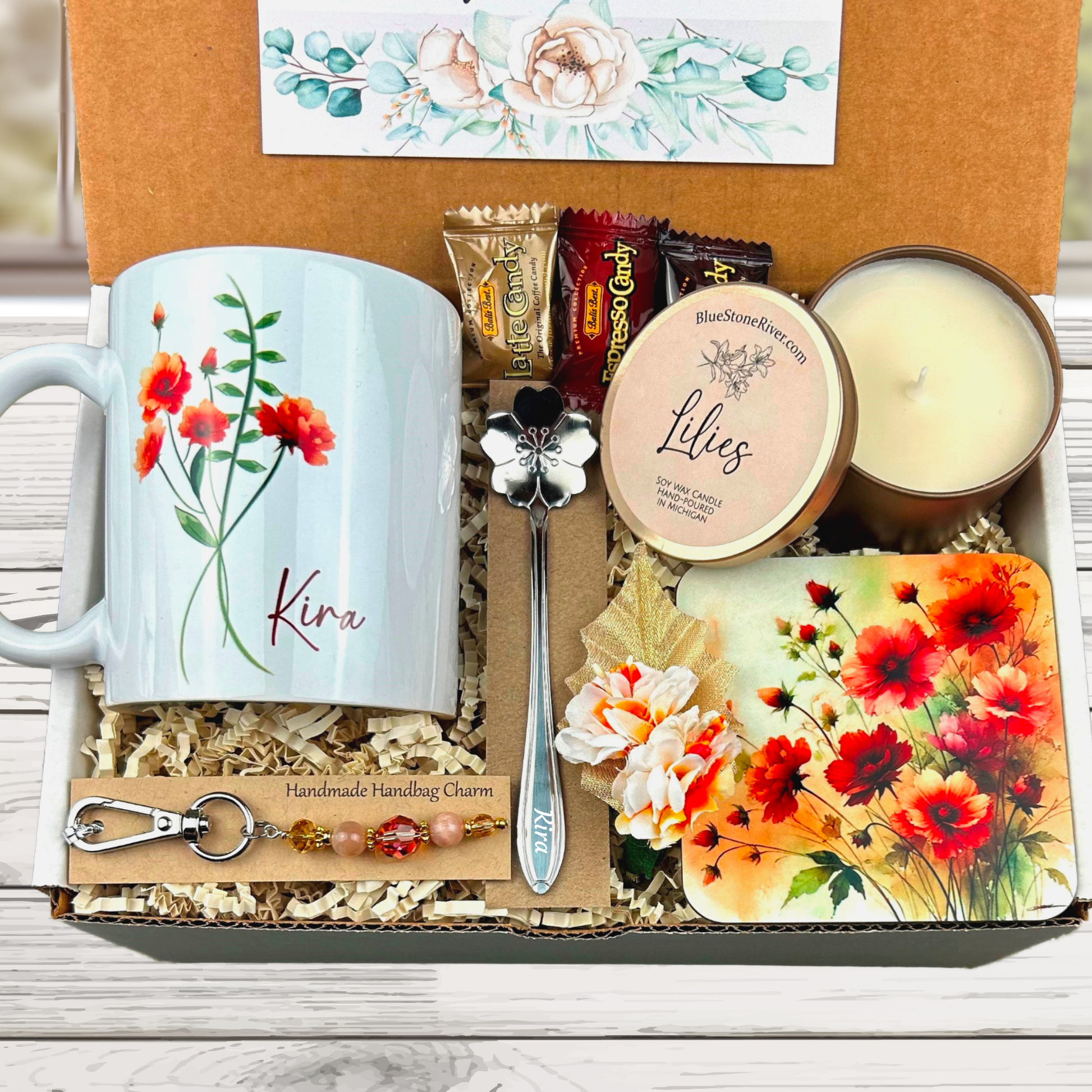 orange flower gift basket with personalized mug, candle, engraved spoon, matching coaster and scented candle.