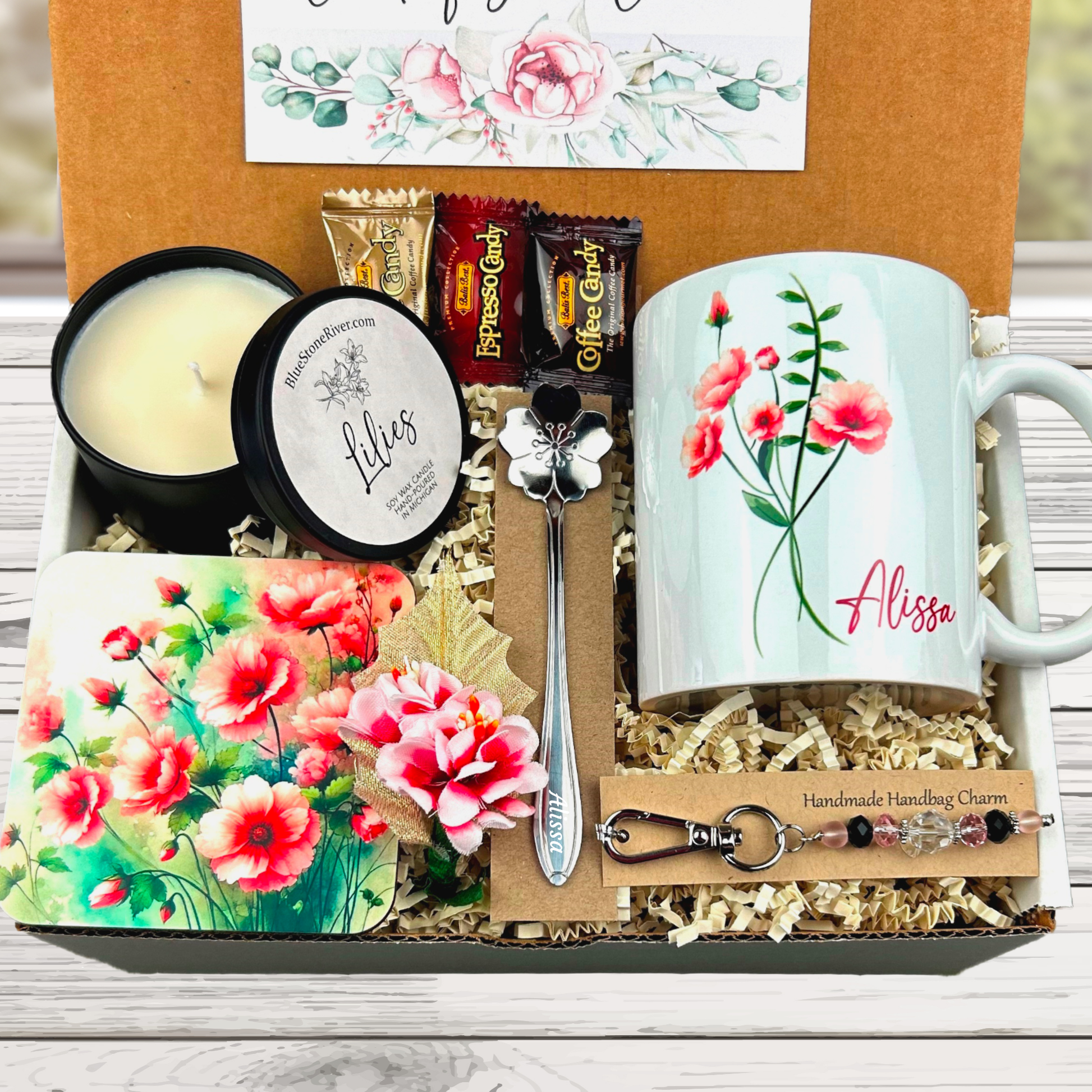 pink flower gift basket with personalized mug, candle, engraved spoon, matching coaster and scented candle.