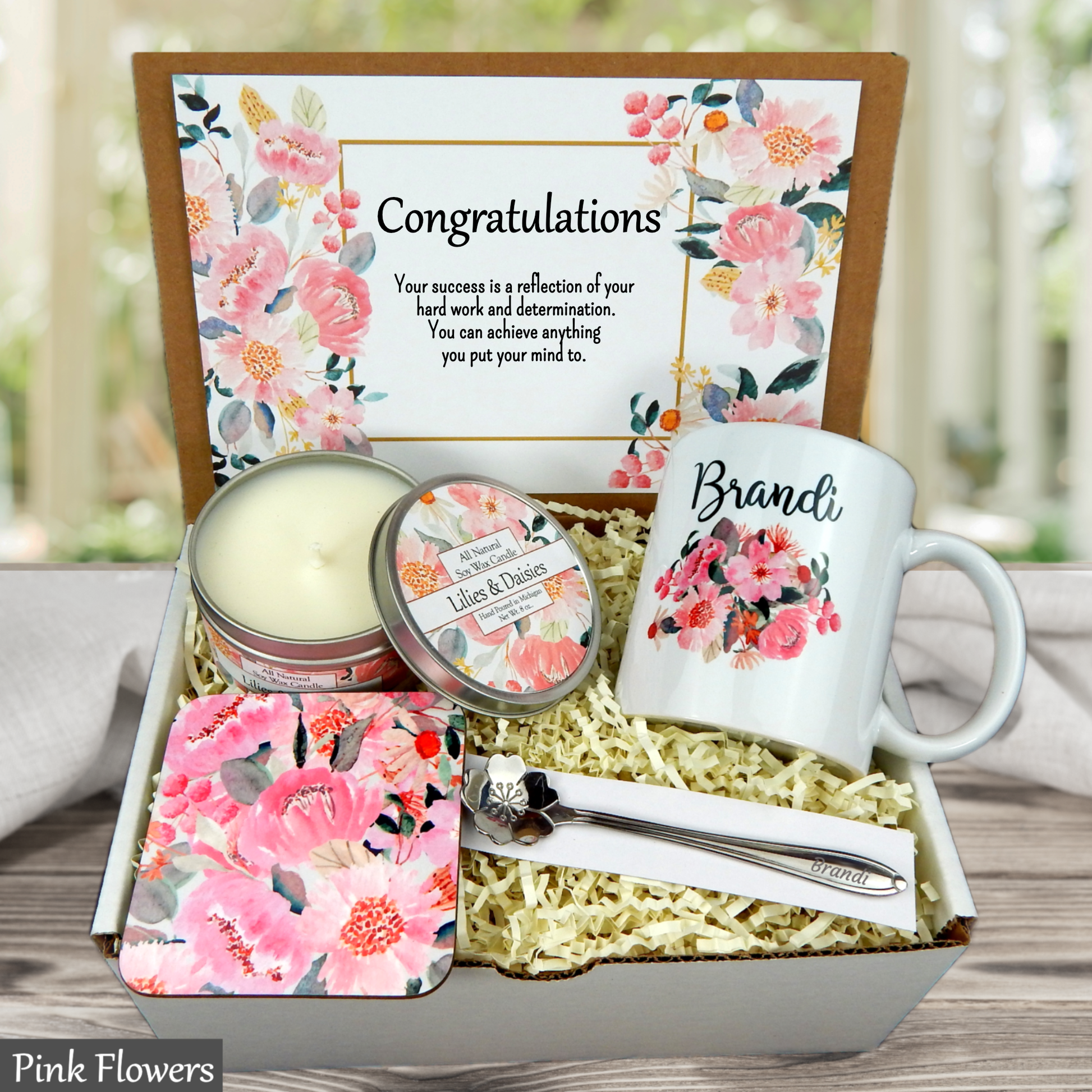 Pink floral Gift set with mug, candle, and other items in a decorative box with floral design and 'Congratulations' message.