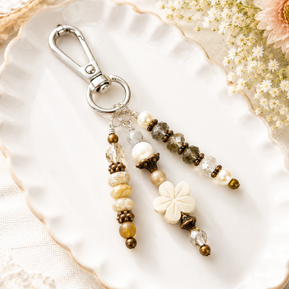 Beaded purse charm with floral design on a decorative plate with flowers