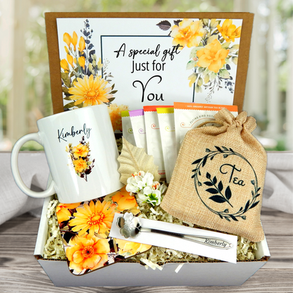Yellow Flower themed Personalized mug and engraved spoon set accompanied by a large 8-ounce scented candle, an assortment of five artisan teas, and a matching coaster set for women